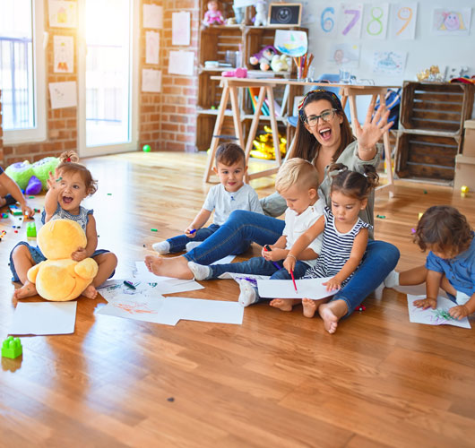 Children sitting on the floor during a creative activity.