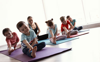 Children learning to stretch and warm up before exercising at Little Lights Childcare