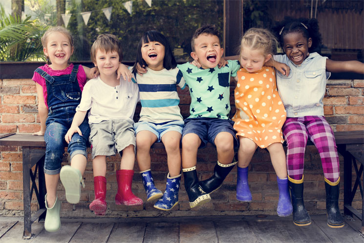 Happy children with arms on each others' shoulders in a companionable way